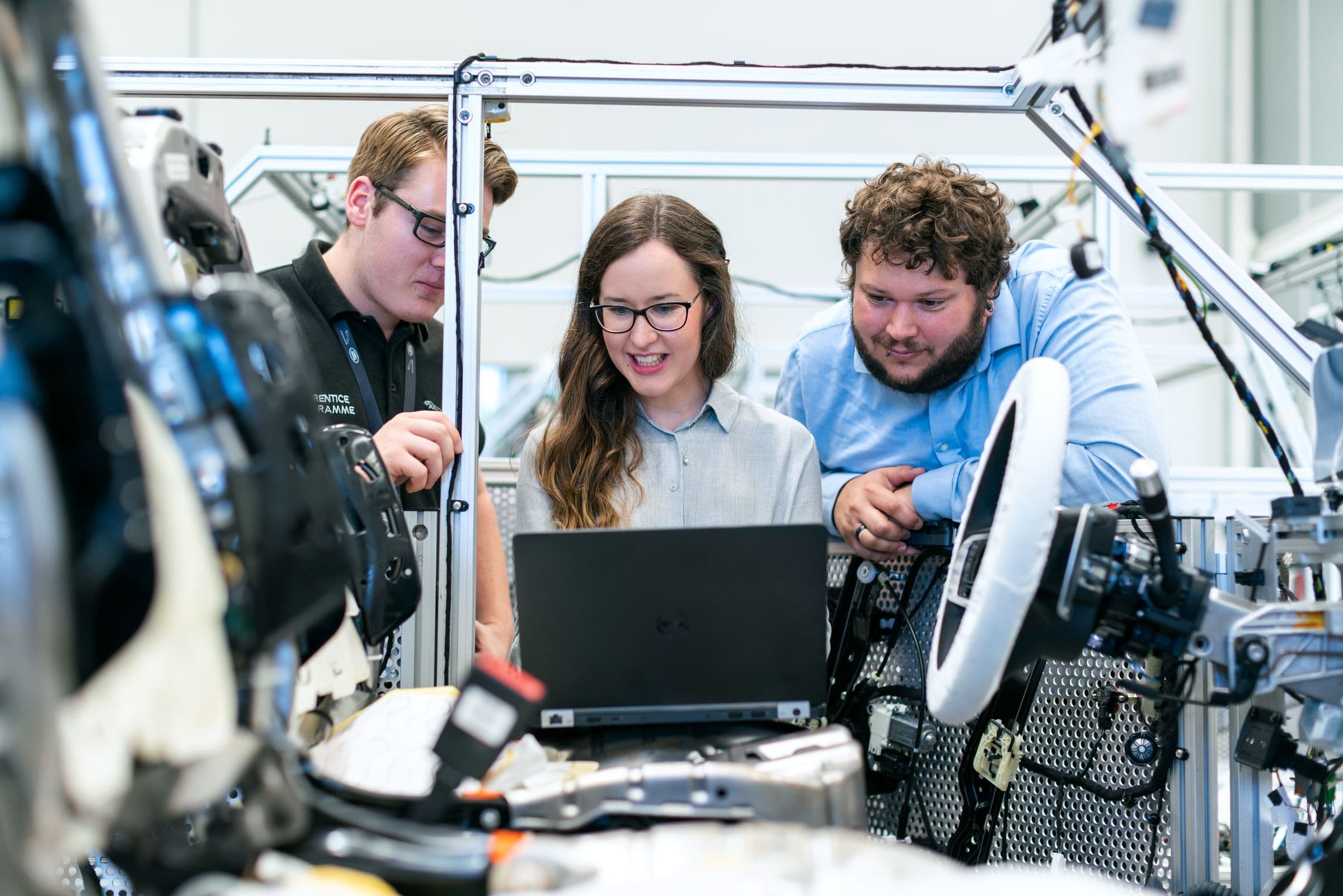 Young operators reviewing data on a laptop inside a manufacturing plant